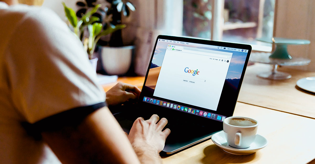 Person typing into Google search on a laptop