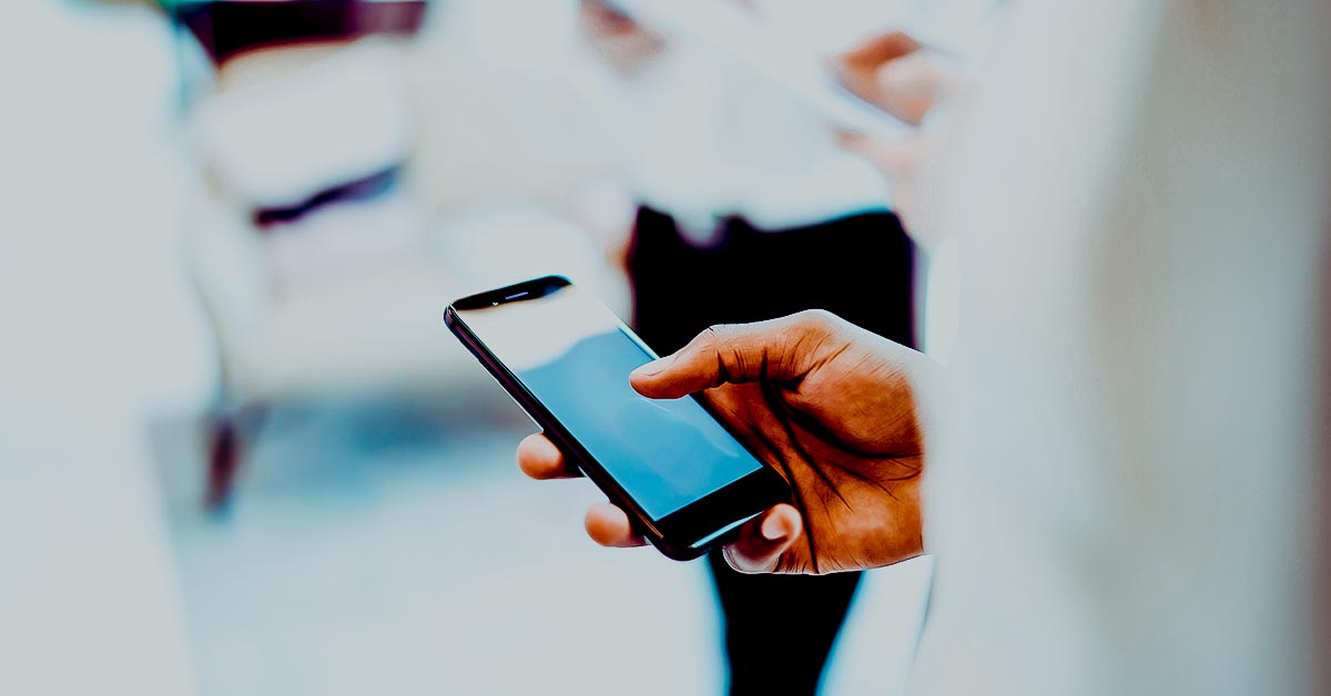 Hand holding a cellphone with a blank screen
