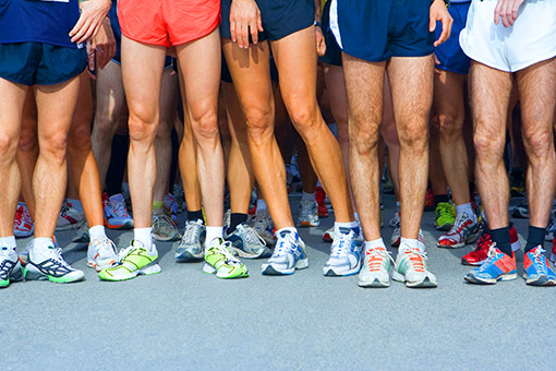Legs of male runners and their sneakers