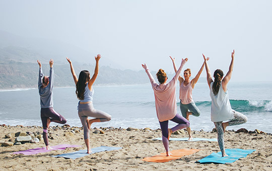 People on the beach doing yoga