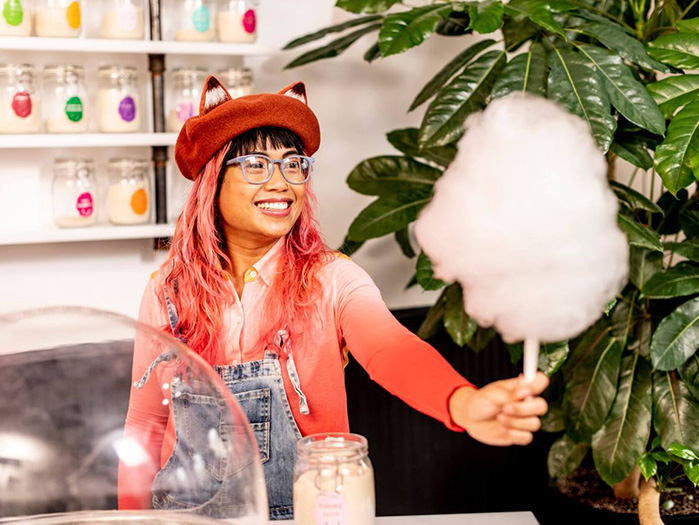 A woman in glasses holding cotton candy