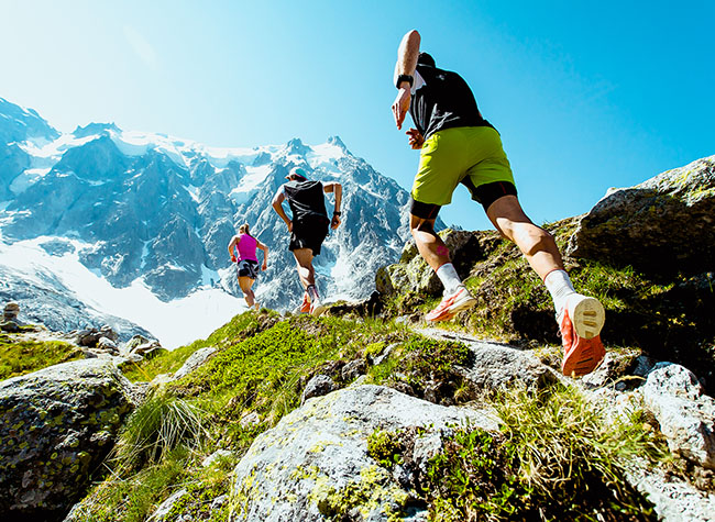 3 people running up a mountain