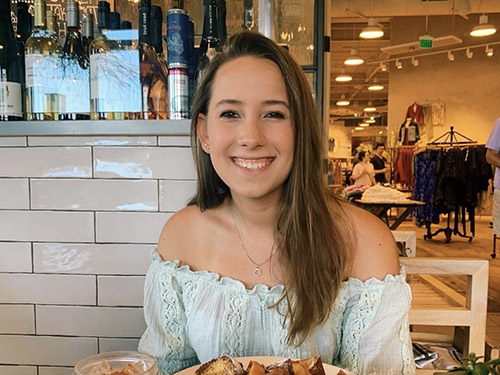 Maya sitting in a restuarant, smiling
