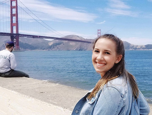 Maya standing in front of a bridge