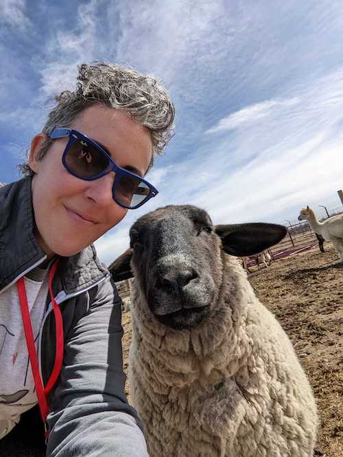 Erin Mulrooney posing for selfie with a sheep