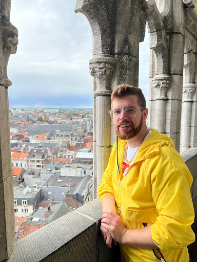 Image of Greg Erickson smiling at camera in front of city scape